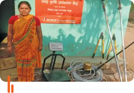 A farmer standing at a farm tool center in Silda village, Khunti district, Jharkhand, with various farming tools displayed. The ICICI Foundation sign is visible in the background, highlighting support for local agricultural initiatives.