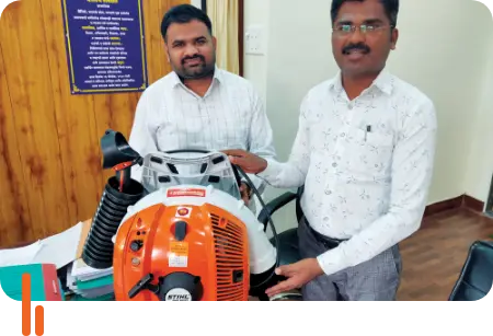 A photograph of two individuals with firefighting equipment provided by ICICI Foundation to Bhimashankar Wildlife Sanctuary, showcasing the foundation's support for fire prevention and safety in the sanctuary.