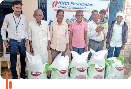 A photograph of farmers in Chandrapur district, Maharashtra, standing with bags of crop seeds distributed by ICICI Foundation as part of its Rural Livelihood program, aimed at supporting agricultural development and farmers' livelihoods.