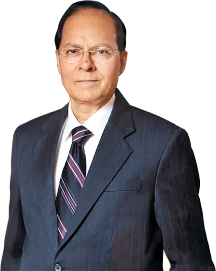 A professional portrait of Girish Chandra Chaturvedi, Chairman, dressed in a dark business suit with a white shirt and striped tie. The individual stands confidently against a simple background, symbolizing leadership and professionalism.