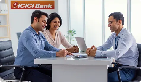 A photo of three individuals engaged in a meeting at an ICICI Bank office. The image represents the bank's commitment to the philosophy Fair to Customer, Fair to Bank, highlighting the focus on building mutually beneficial customer relationships and fostering trust in the brand. The setting is a modern office with a professional and collaborative atmosphere.